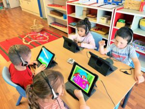 Child learning digital skills on an interactive screen in school readiness program